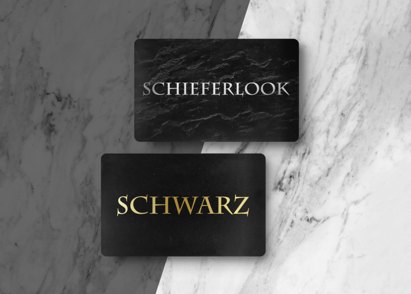 eine schwarze glänzende und eine schwarze schieferlook Karte als Vergleich dargestellt mit einem Marmor ähnlichen Hintergrund