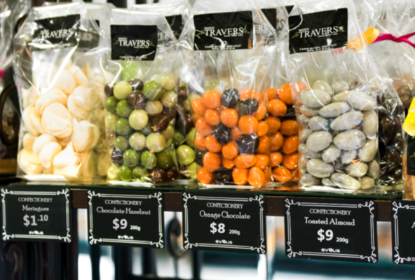 Confiserie-Regal mit Süssigkeiten und Karten-Beschriftung